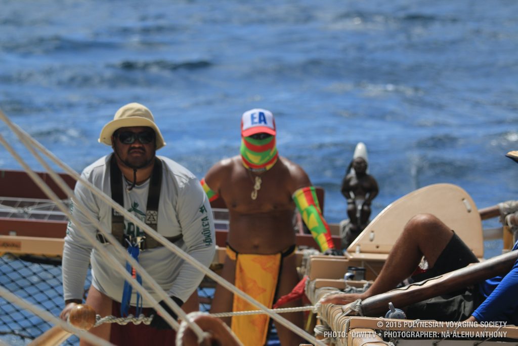 Crewmembers Kaina and Kealoha steer Hōkūleʻa with a pretty large swell behind them.