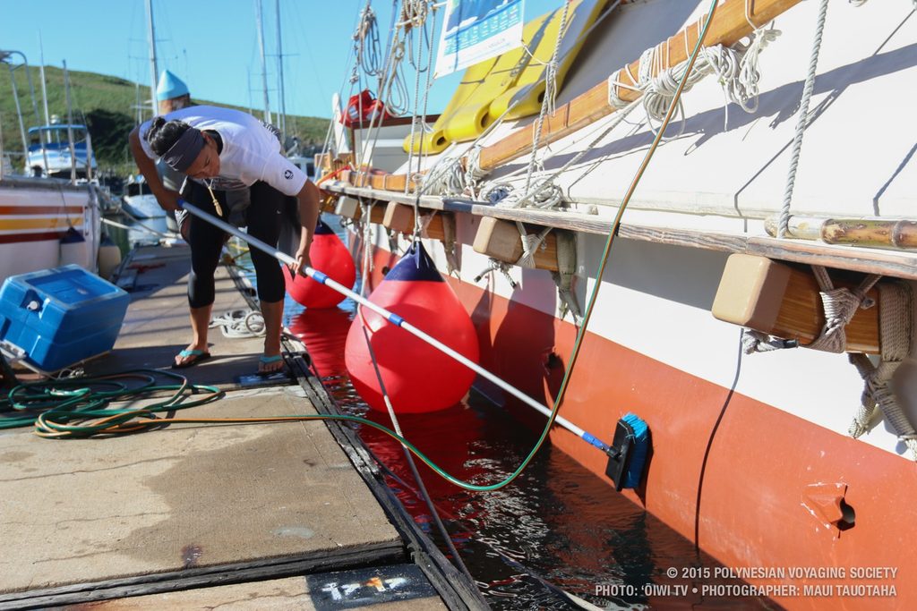 Ana scrubbing algae growth off of the hulls.